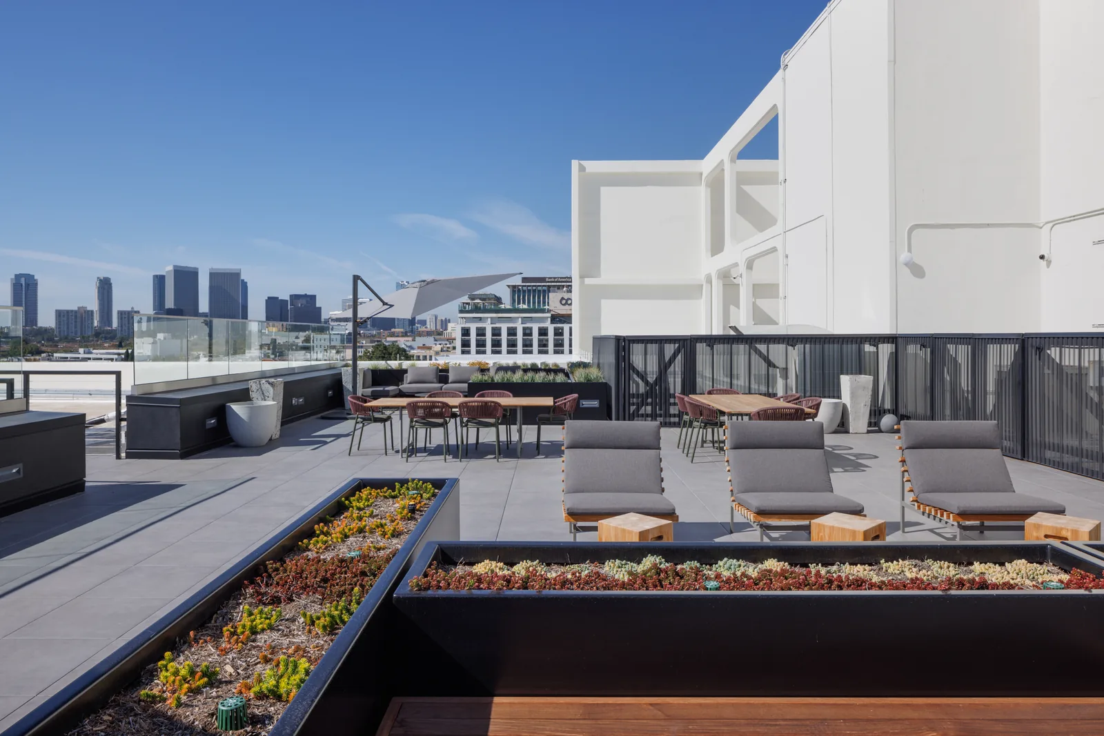 Rooftop lounge with sofas and planters overlooking downtown