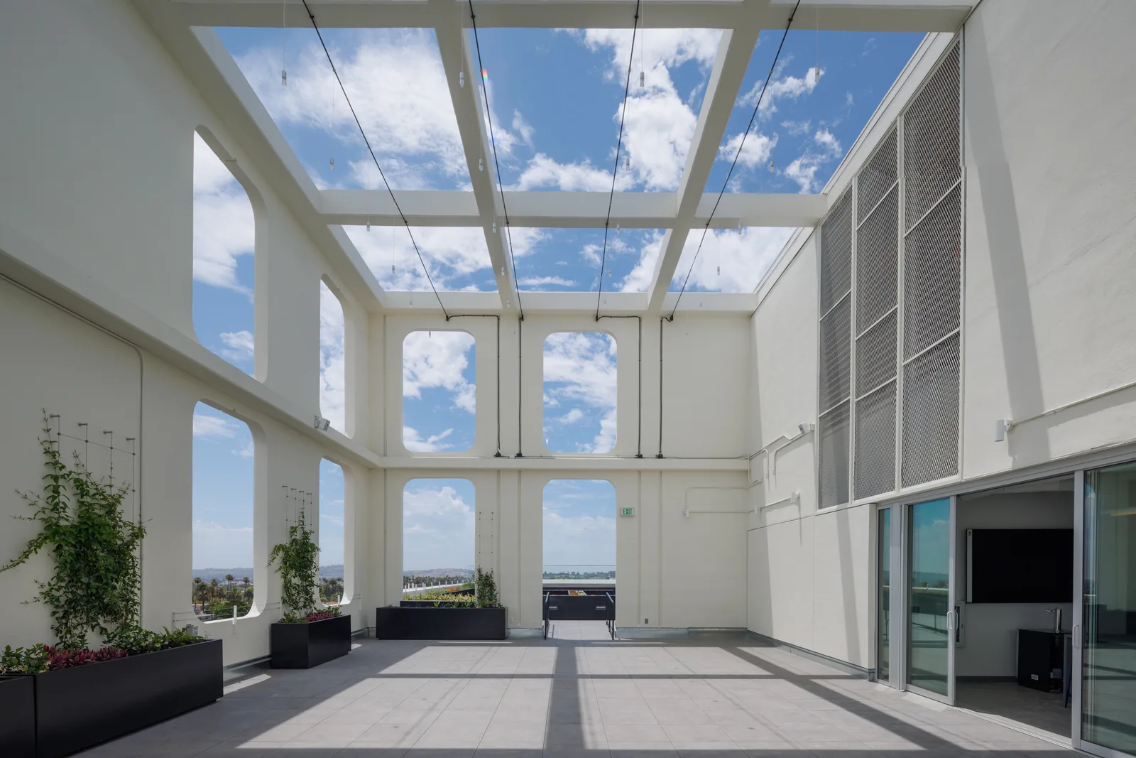 Open-beam pergola over the rooftop terrace with planted walls