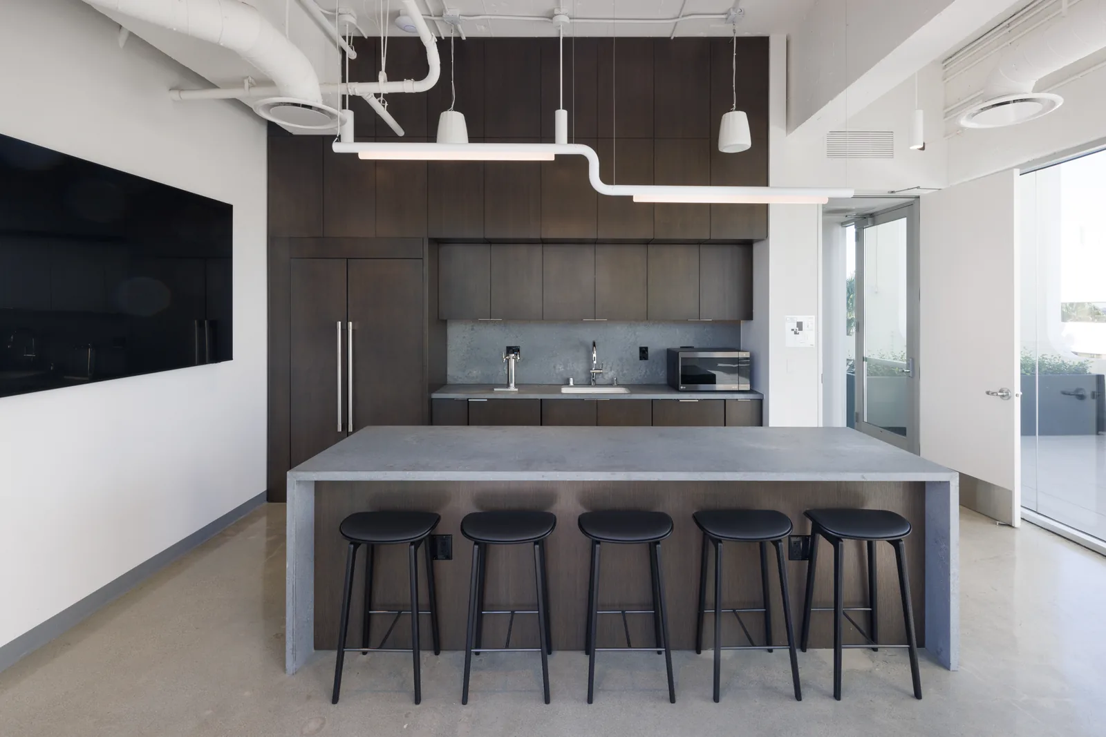 Catering kitchen with concrete island and seating